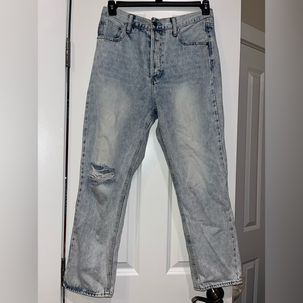 Distressed jeans, have a hole in the knee, and washed detailing. Light blue.